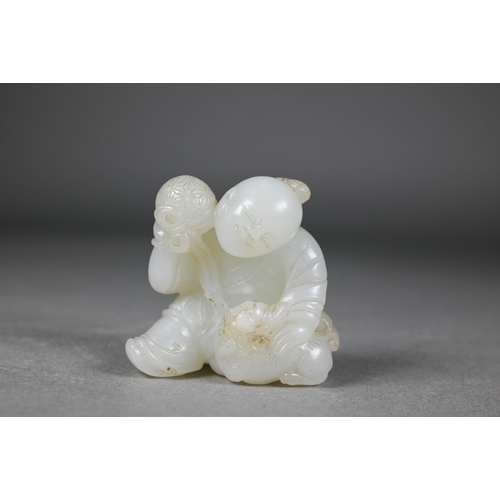 384 - An 18th century Chinese jade carving of a boy and karashisi playing with a ribbon tied brocade ball,... 