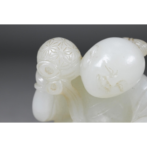 384 - An 18th century Chinese jade carving of a boy and karashisi playing with a ribbon tied brocade ball,... 