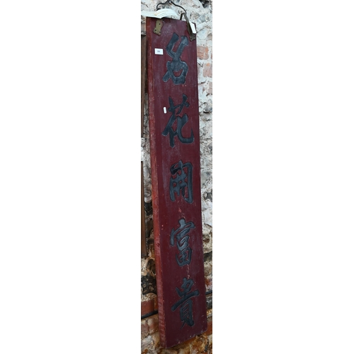 386 - A Chinese red lacquered hardwood and brass mounted vertical sign-board carved with a five character ... 