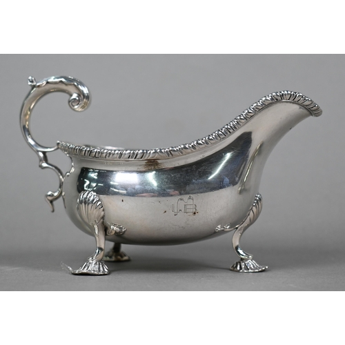 47 - An Edwardian silver pot-bellied cream boat in the Georgian manner, with gadrooned rim, scroll handle... 