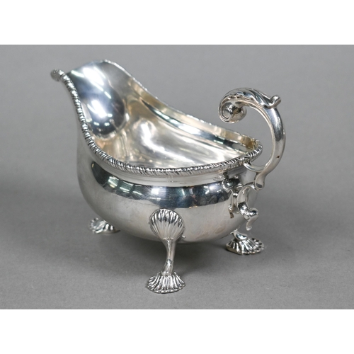 47 - An Edwardian silver pot-bellied cream boat in the Georgian manner, with gadrooned rim, scroll handle... 