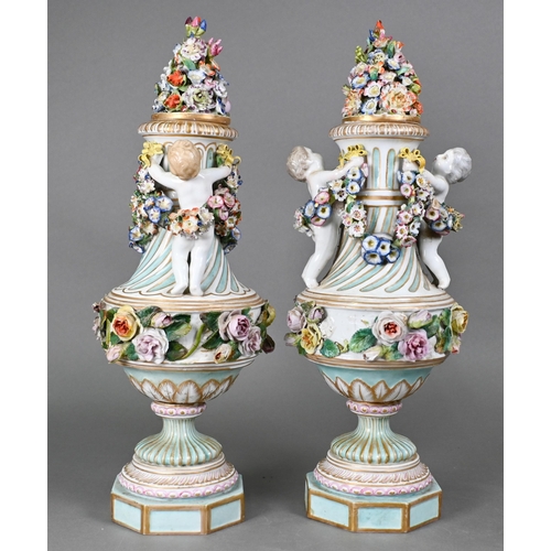 489 - A pair of 19th century Meissen garniture vases, with floral-encrusted covers above twin putti handle... 