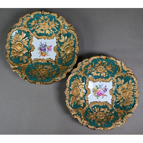 490 - A pair of early 20th century Meissen cabinet plates, painted with floral sprays within richly emboss... 