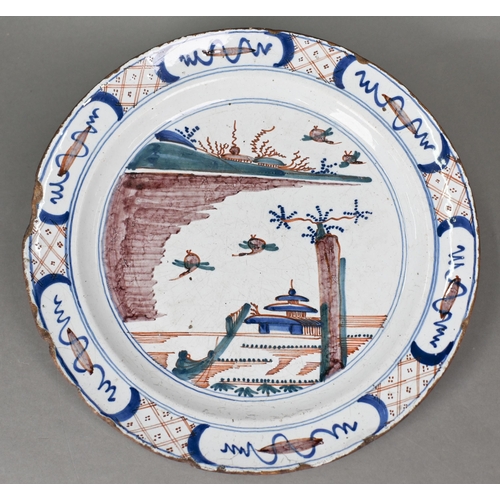 505 - An 18th century polychrome Delft charger, painted with traditional coastal landscape with ducks land... 