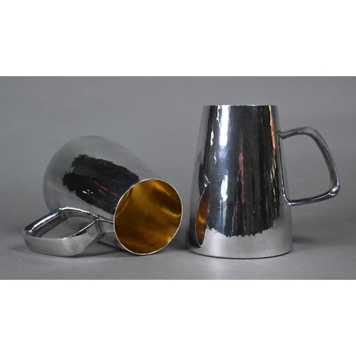 51 - Gerald Benney (1930-2008), a pair of planished silver mugs of tapering form with angular loop handle... 