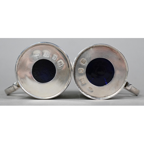 56 - A pair of heavy quality silver drum mustards with scrolling thumbpieces and blue glass liners, Rodne... 