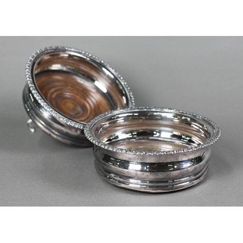 6 - A pair of plated bottle coasters with gadrooned rims and turned wood bases, 15cm diameter, to/w an e... 