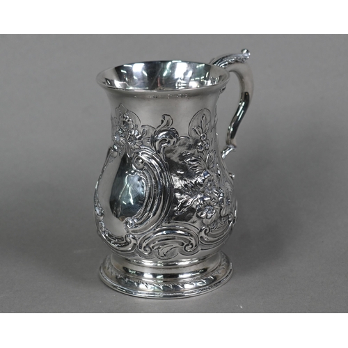 68 - A George III silver baluster mug, later embossed and chased with rococo scrolls and flowers, with sc... 