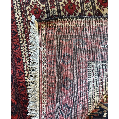775 - A small Afghan Baluch rug with repeating geometric design on camel ground, red borders, 205 x 100 cm