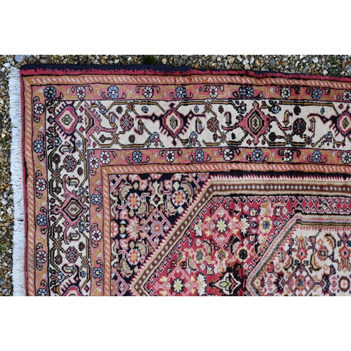 777 - A Persian Bijar rug, thick pile with complex Herati design on terracotta ground, blue spandrels and ... 
