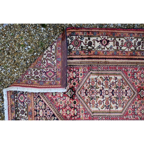 777 - A Persian Bijar rug, thick pile with complex Herati design on terracotta ground, blue spandrels and ... 
