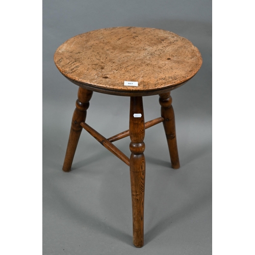 807 - An antique walnut and elm cricket table, the circular top raised on three turned legs united by a t-... 