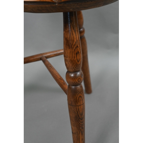 807 - An antique walnut and elm cricket table, the circular top raised on three turned legs united by a t-... 