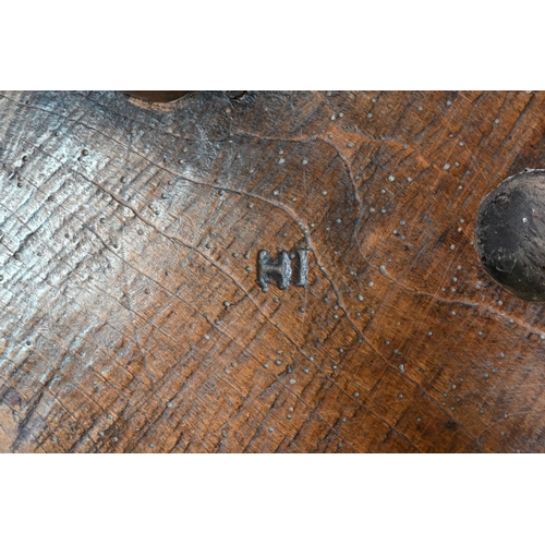 807 - An antique walnut and elm cricket table, the circular top raised on three turned legs united by a t-... 