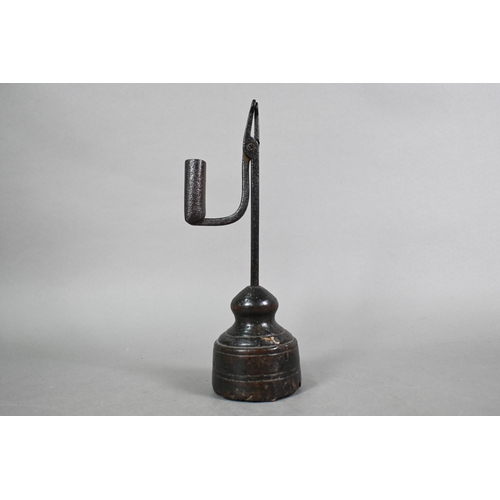 809 - An 18th century wrought iron pivoting rush light holder, raised on a wood block base, 28 cm h, evide... 