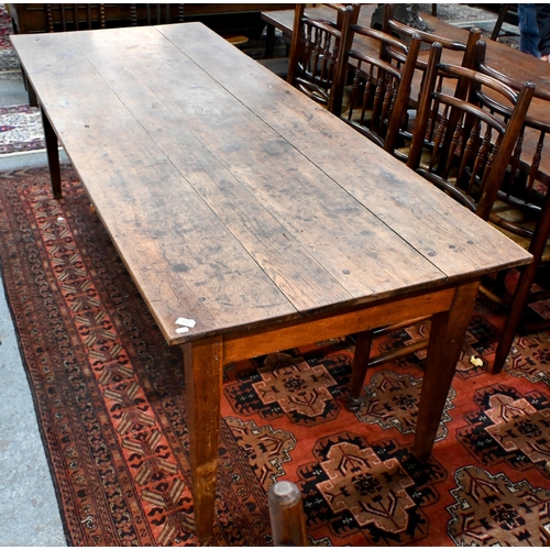 827 - An antique French oak refectory dining table, the plank top over two frieze drawers to one side, rai... 