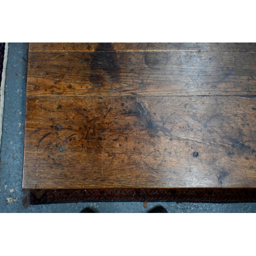 827 - An antique French oak refectory dining table, the plank top over two frieze drawers to one side, rai... 