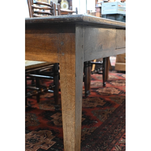 827 - An antique French oak refectory dining table, the plank top over two frieze drawers to one side, rai... 