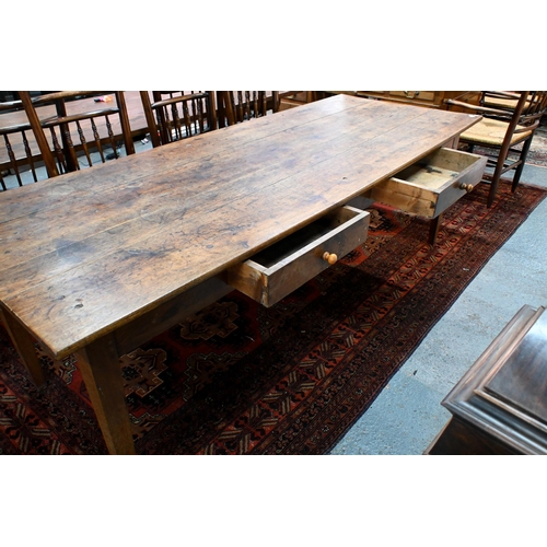 827 - An antique French oak refectory dining table, the plank top over two frieze drawers to one side, rai... 