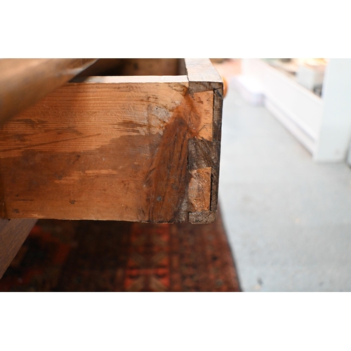 827 - An antique French oak refectory dining table, the plank top over two frieze drawers to one side, rai... 