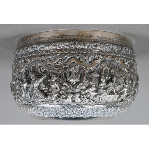 35 - A Burmese low grade silver bowl, embossed and chased with deities and animals in woodland settings, ... 