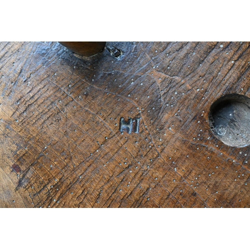 807 - An antique walnut and elm cricket table, the circular top raised on three turned legs united by a t-... 