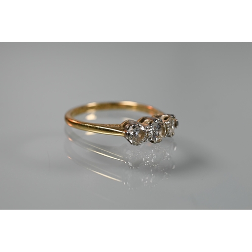 196 - A three-stone diamond ring, claw set in 18ct yellow gold and platinum setting, size L