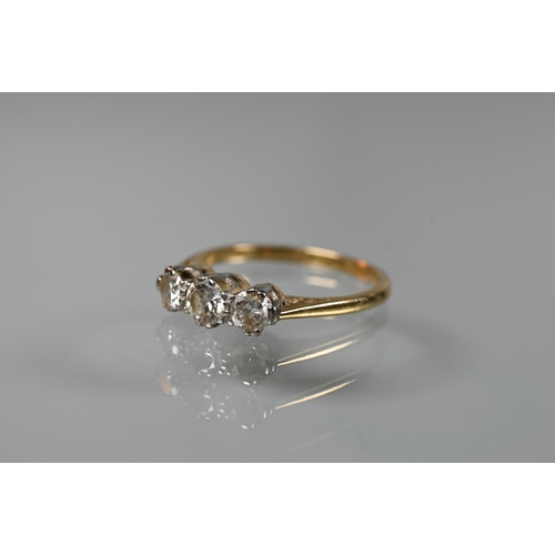 196 - A three-stone diamond ring, claw set in 18ct yellow gold and platinum setting, size L