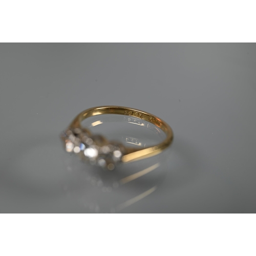 196 - A three-stone diamond ring, claw set in 18ct yellow gold and platinum setting, size L