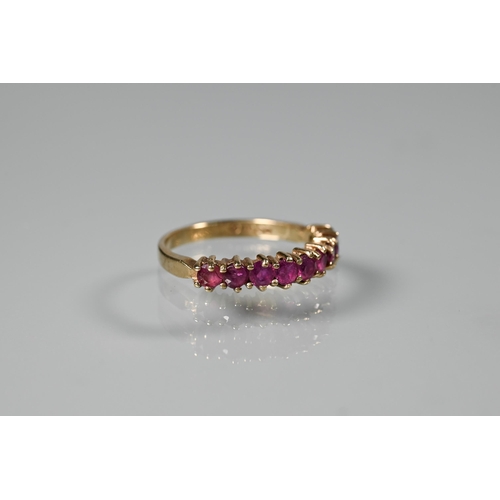 261 - A 9ct yellow gold ring set with nine garnets, size M