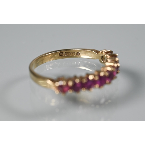 261 - A 9ct yellow gold ring set with nine garnets, size M