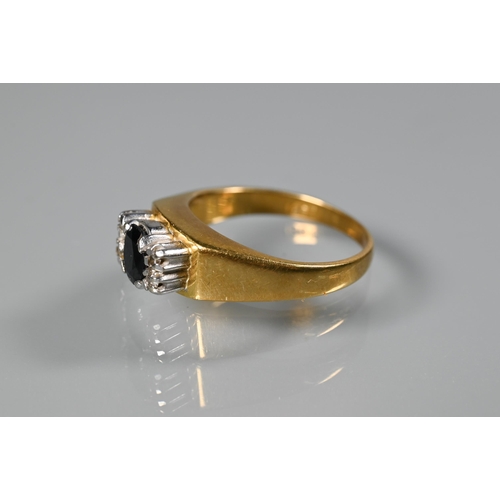 262 - An 18ct yellow gold ring set central oval dark blue sapphire with two small diamonds to each side, s... 