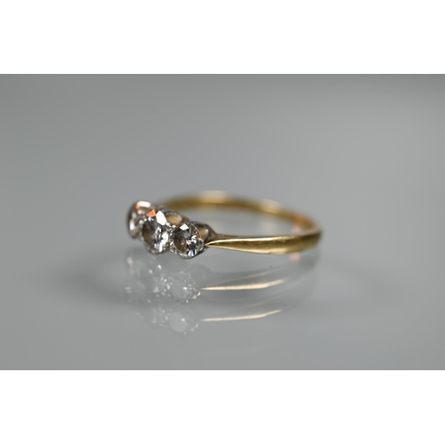 285 - A three-stone claw set diamond ring, yellow and white gold stamped 18ct and plat, size P 1/2