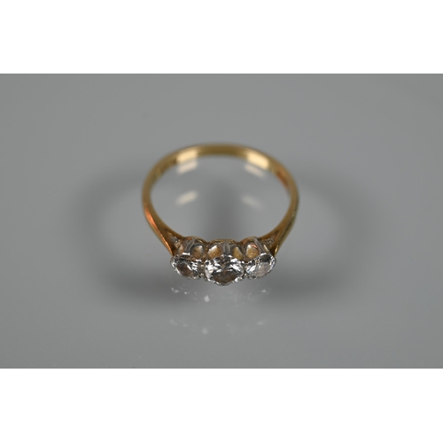 285 - A three-stone claw set diamond ring, yellow and white gold stamped 18ct and plat, size P 1/2