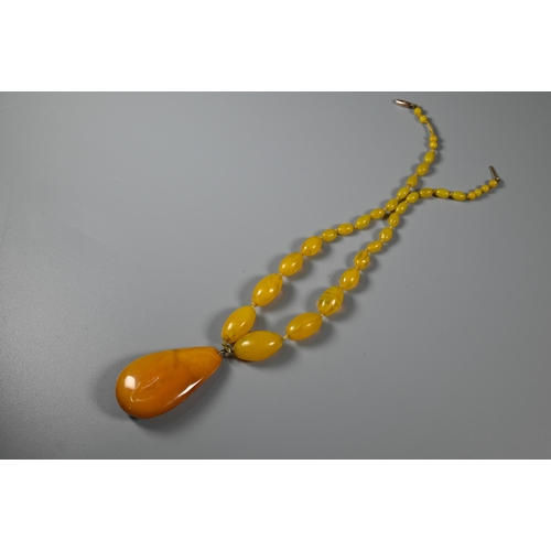 301 - A contemporary white metal necklace formed of textured roundels; a tiger's eye pear-shaped pendant o... 