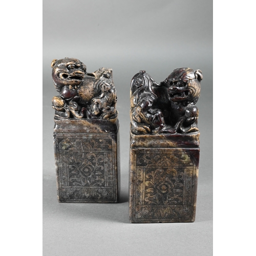 361 - A pair of early 20th century Chinese soapstone desk seals carved with Buddhistic guardian lions and ... 