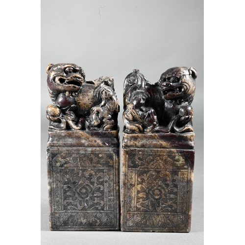 361 - A pair of early 20th century Chinese soapstone desk seals carved with Buddhistic guardian lions and ... 