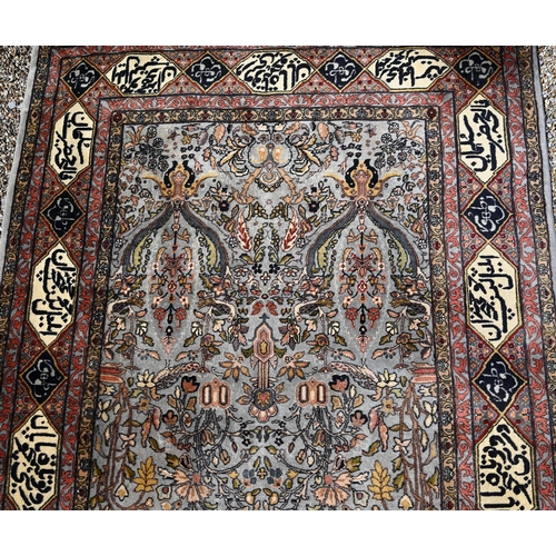 762 - An old Persian Tabriz blue-grey grey ground rug, the borders with kufic panels, inscribed in Arabic,... 