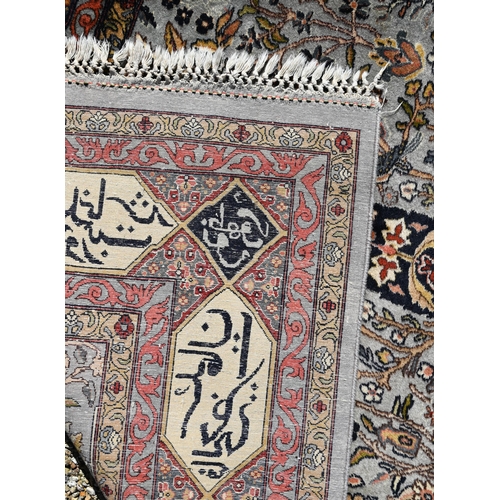 762 - An old Persian Tabriz blue-grey grey ground rug, the borders with kufic panels, inscribed in Arabic,... 