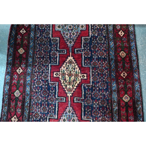 770 - A contemporary North West Persian Senneh runner, with lozenge pole design on red ground, 382 cm x 93... 