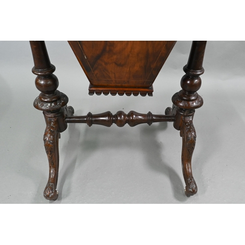 815 - A Victorian walnut veneered work table, the quarter veneered hinged top enclosing a fitted interior ... 