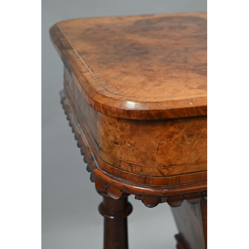 815 - A Victorian walnut veneered work table, the quarter veneered hinged top enclosing a fitted interior ... 