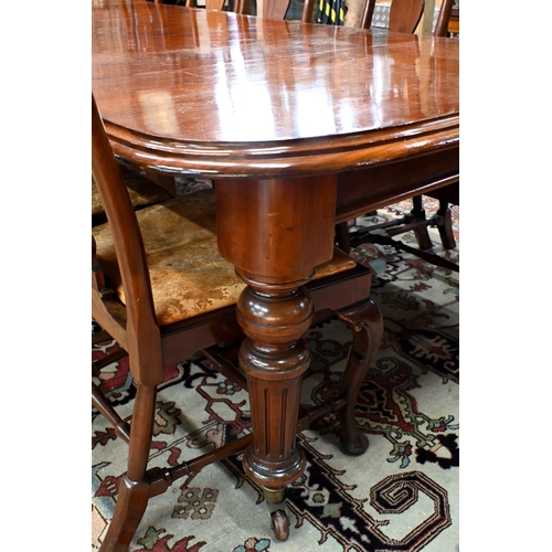 830 - A large Victorian style mahogany extending dining table, the wind action extending to accept three a... 