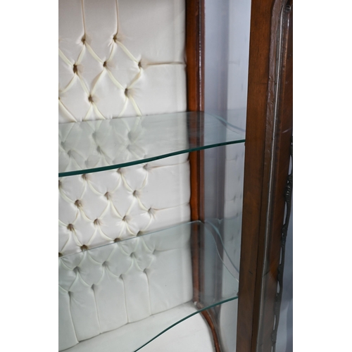 833 - A continental brass mounted kingwood serpentine form salon display cabinet, the interior with button... 