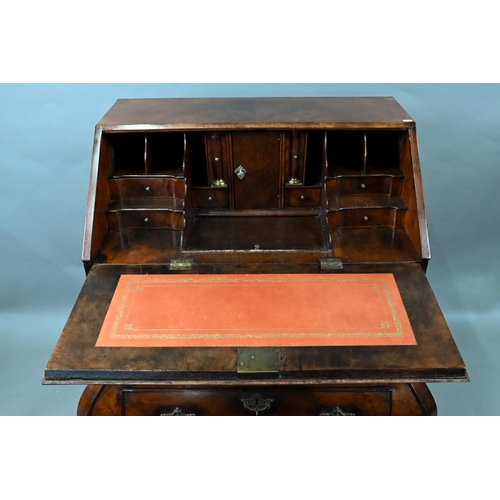 852 - An antique continental walnut 'bombe' bureau, the slope front with leather interior and enclosing a ... 