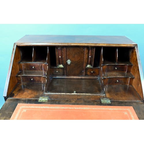 852 - An antique continental walnut 'bombe' bureau, the slope front with leather interior and enclosing a ... 