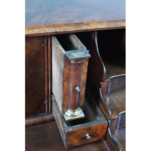 852 - An antique continental walnut 'bombe' bureau, the slope front with leather interior and enclosing a ... 