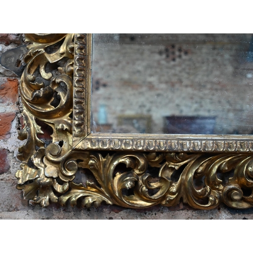 909 - An antique carved foliate scroll formed giltwood framed mirror, 97 cm x 110 cm