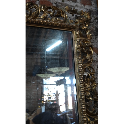 909 - An antique carved foliate scroll formed giltwood framed mirror, 97 cm x 110 cm