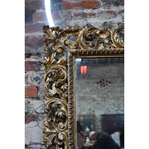 909 - An antique carved foliate scroll formed giltwood framed mirror, 97 cm x 110 cm